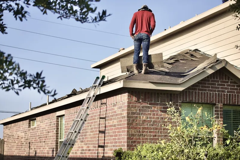 Professional roofer working on a residential roof in East Moriches
